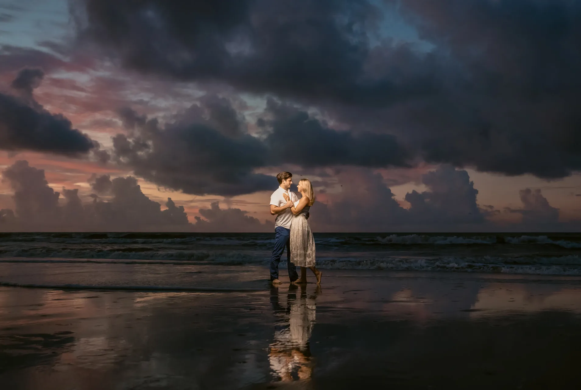 dramatic and moody beach engagement photo of young attractive couple | Kropp Photography - engagement & couples guide