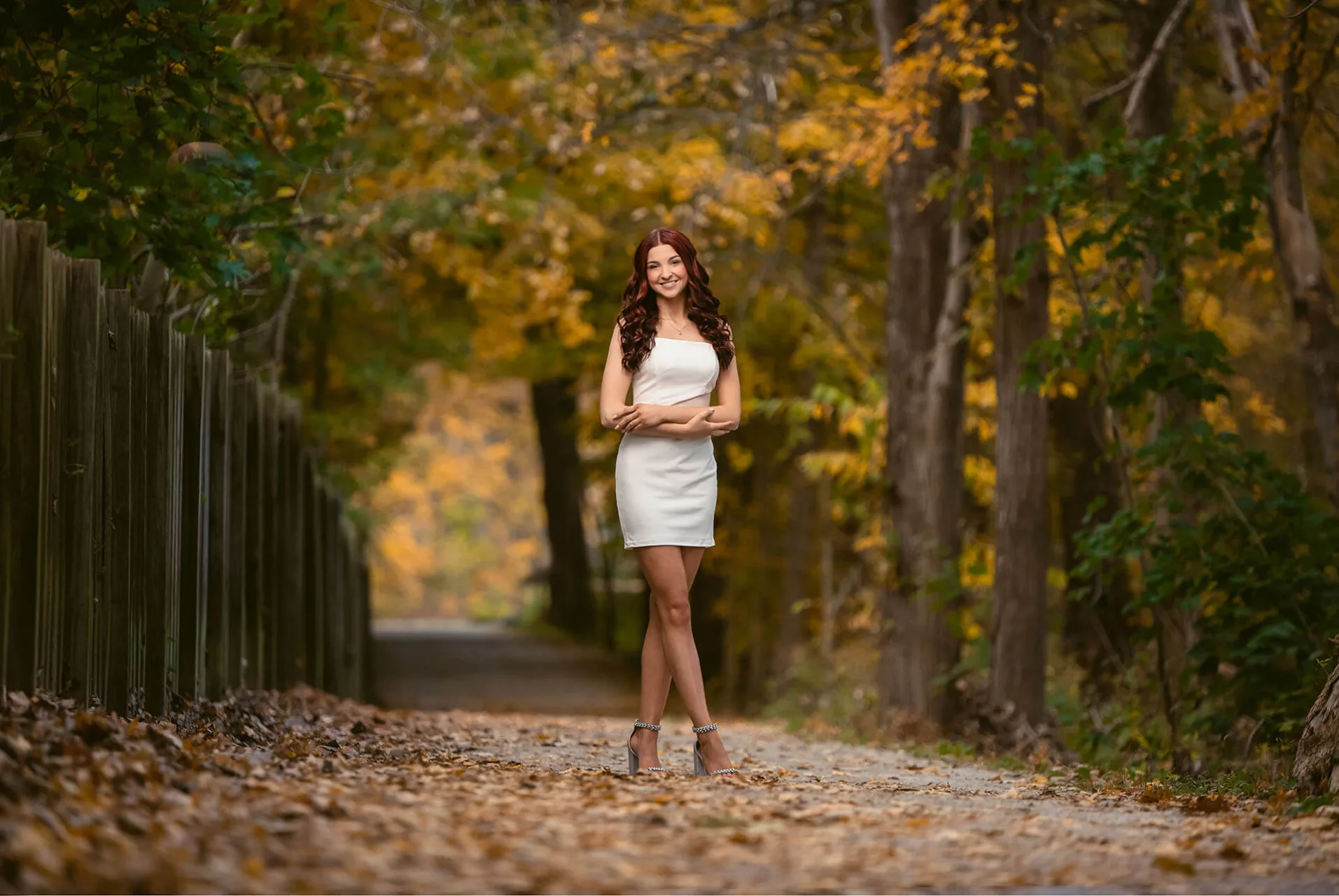 Lovely young lady in a white dress on a path in the fall | Kropp Photography - Senior Portraits Guide