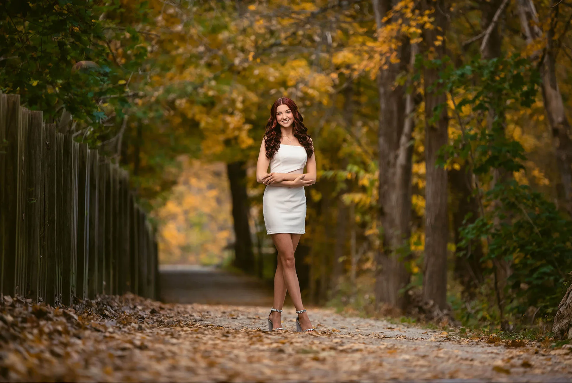 Lovely young lady in a white dress on a path in the fall | Kropp Photography - Senior Portraits Guide