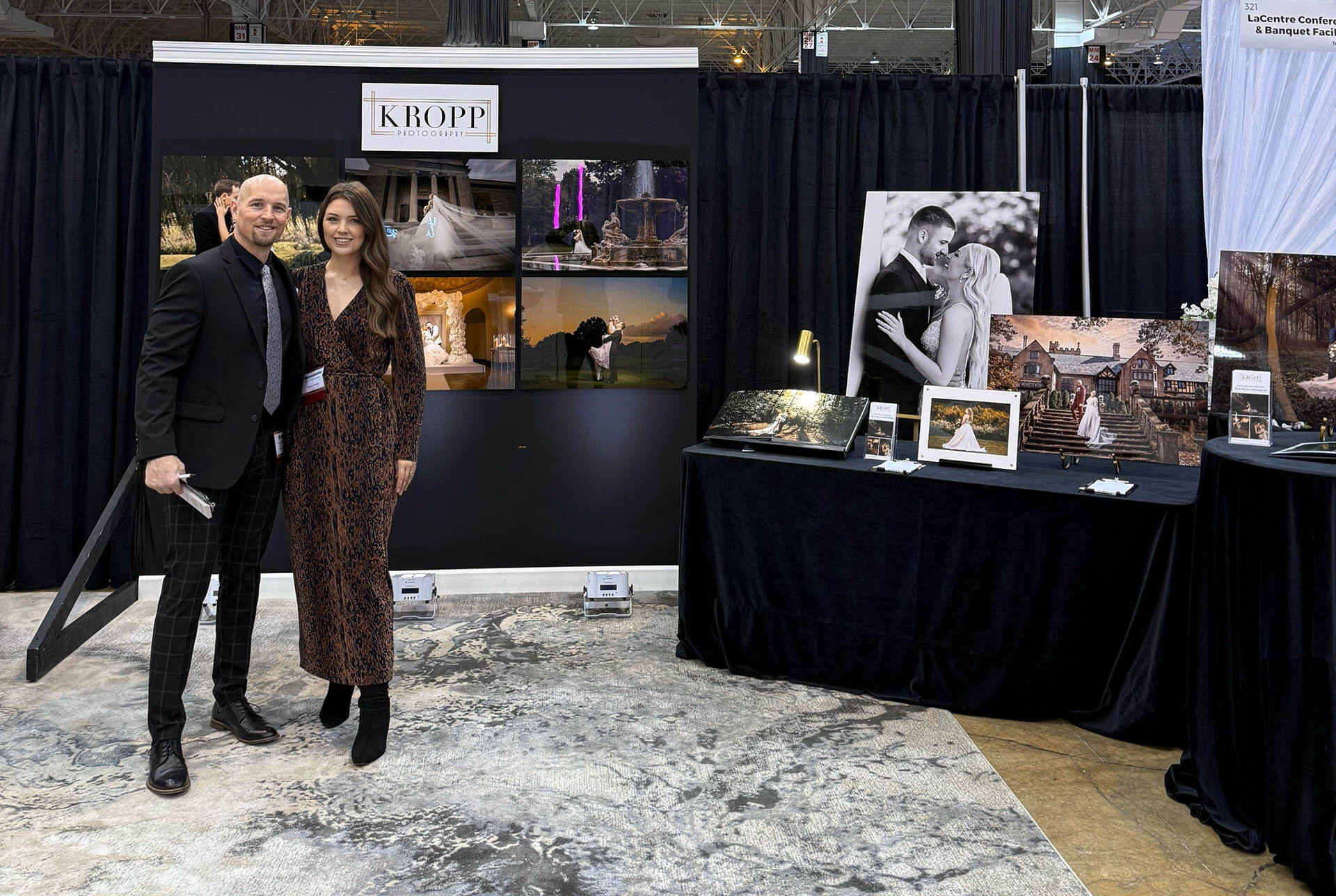 Brian and Samantha Kropp of Kropp Photography standing in their booth at the I-X Center Wedding Show